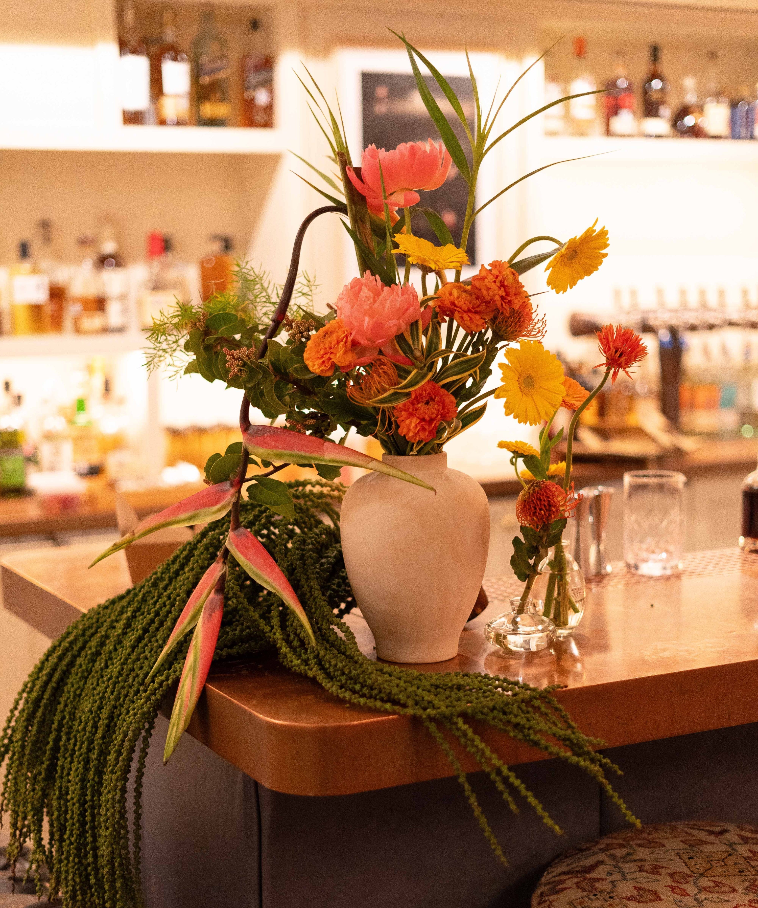 Floral arrangement on a bar counter with a blurred bar background