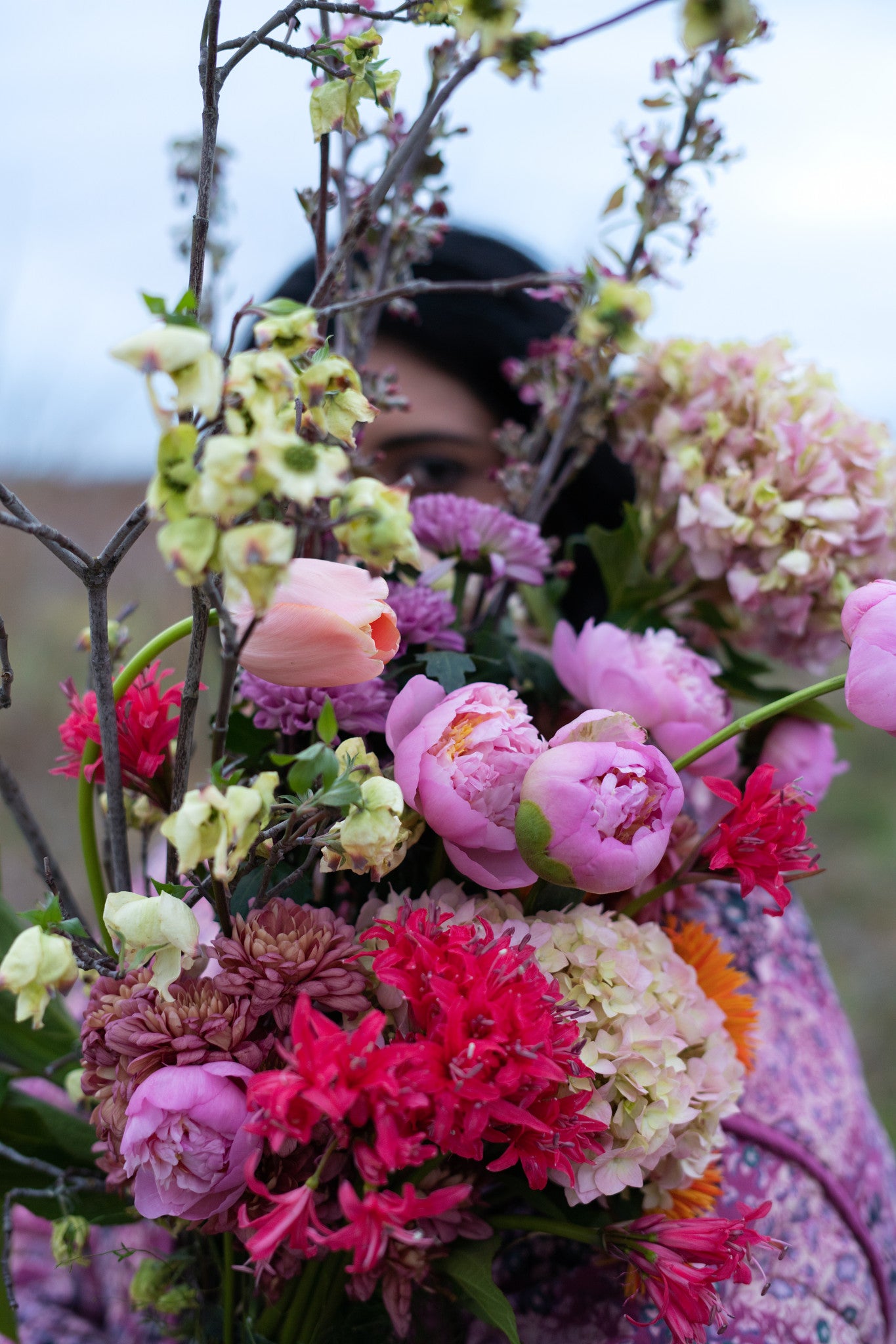 Woman holding a bouquet of colorful flowers with a blurred background in Austin Texas