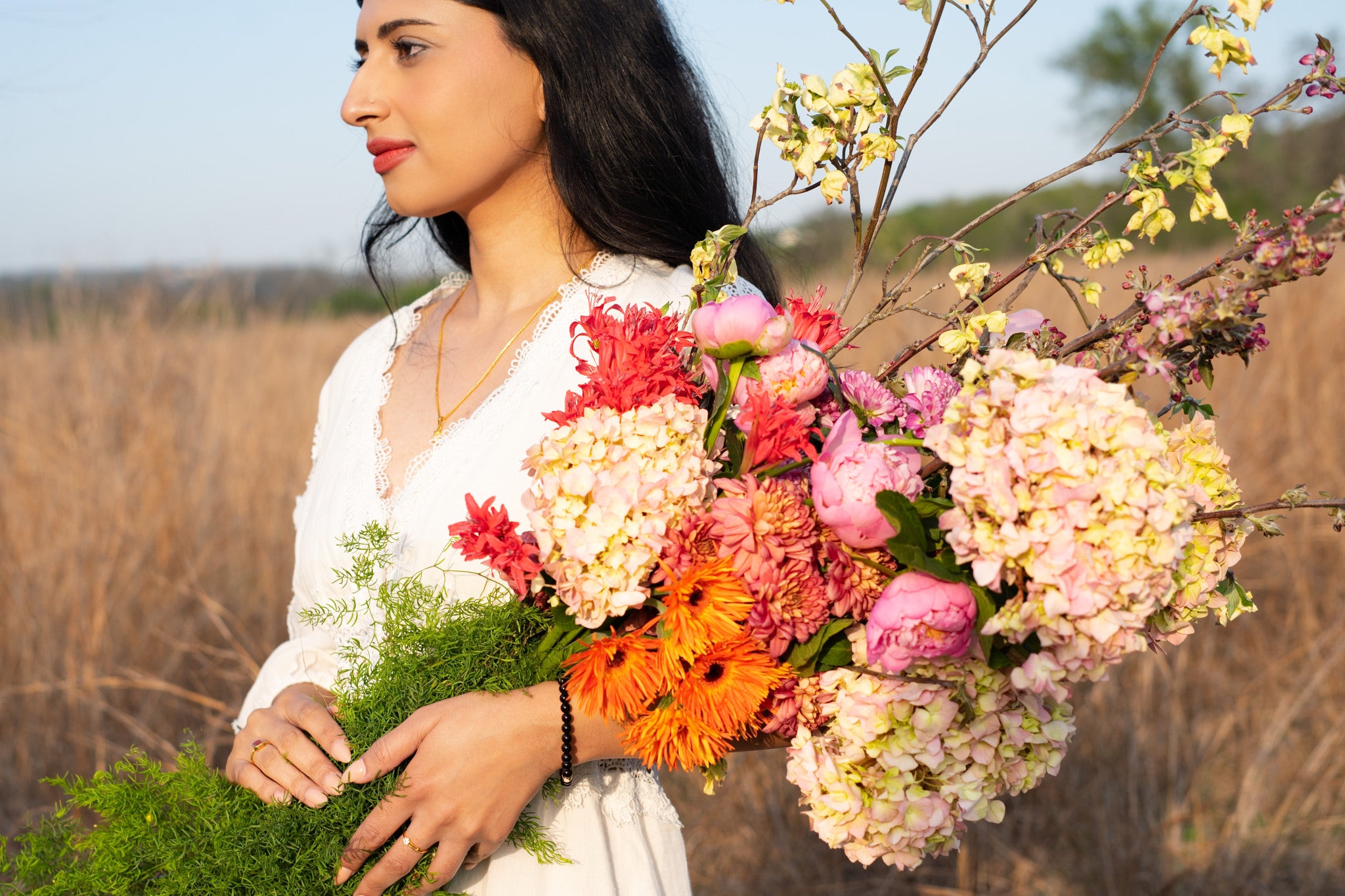 Woman holding a bouquet of flowers in a field in Austin Texas
