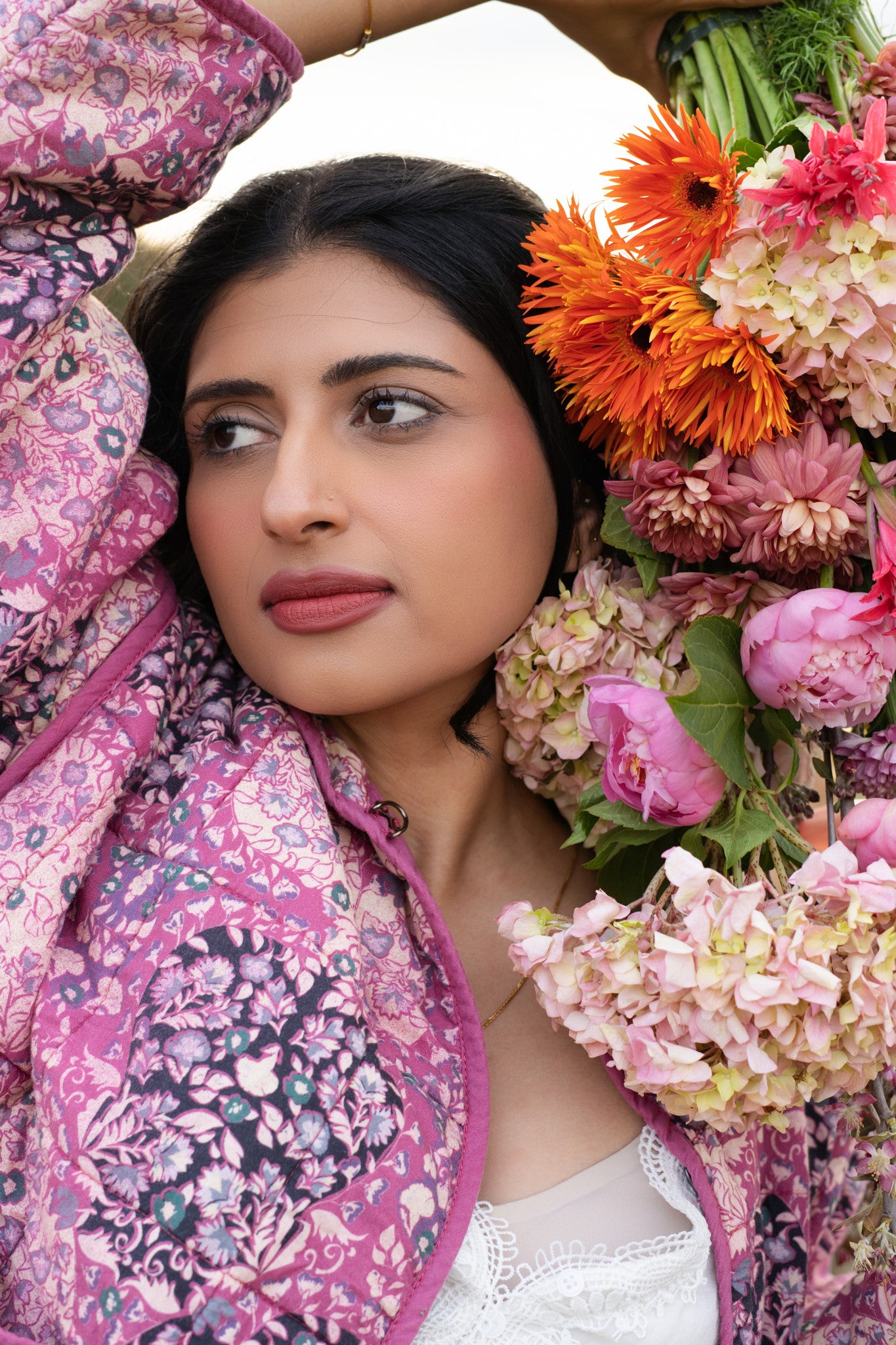 Woman wearing a floral jacket with flowers in the background