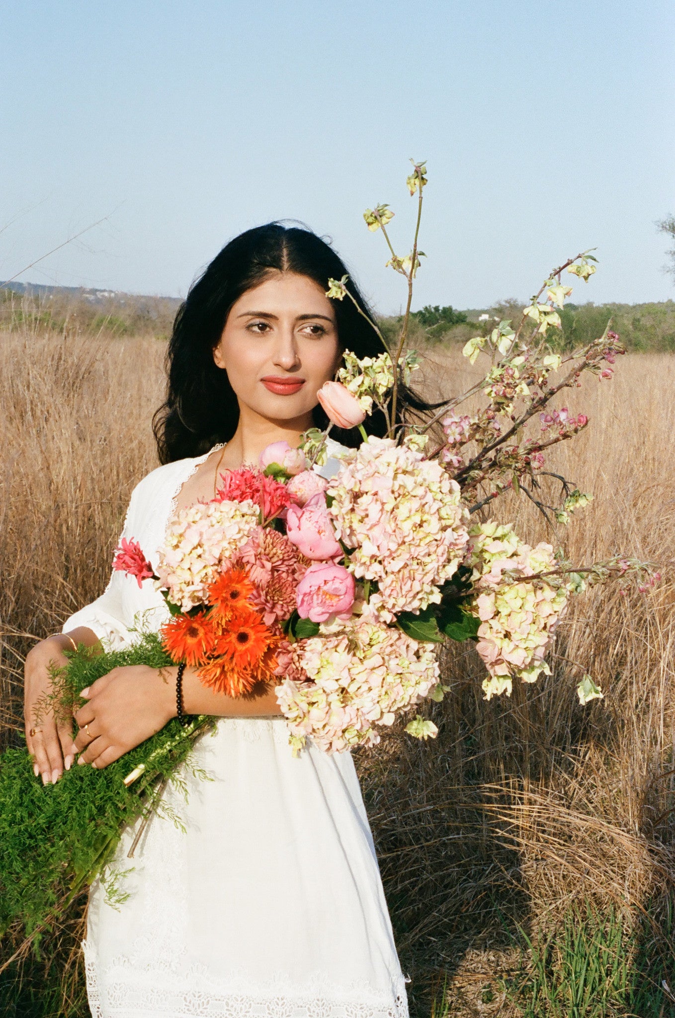 Woman holding a bouquet of flowers in an outdoor setting in Austin Texas